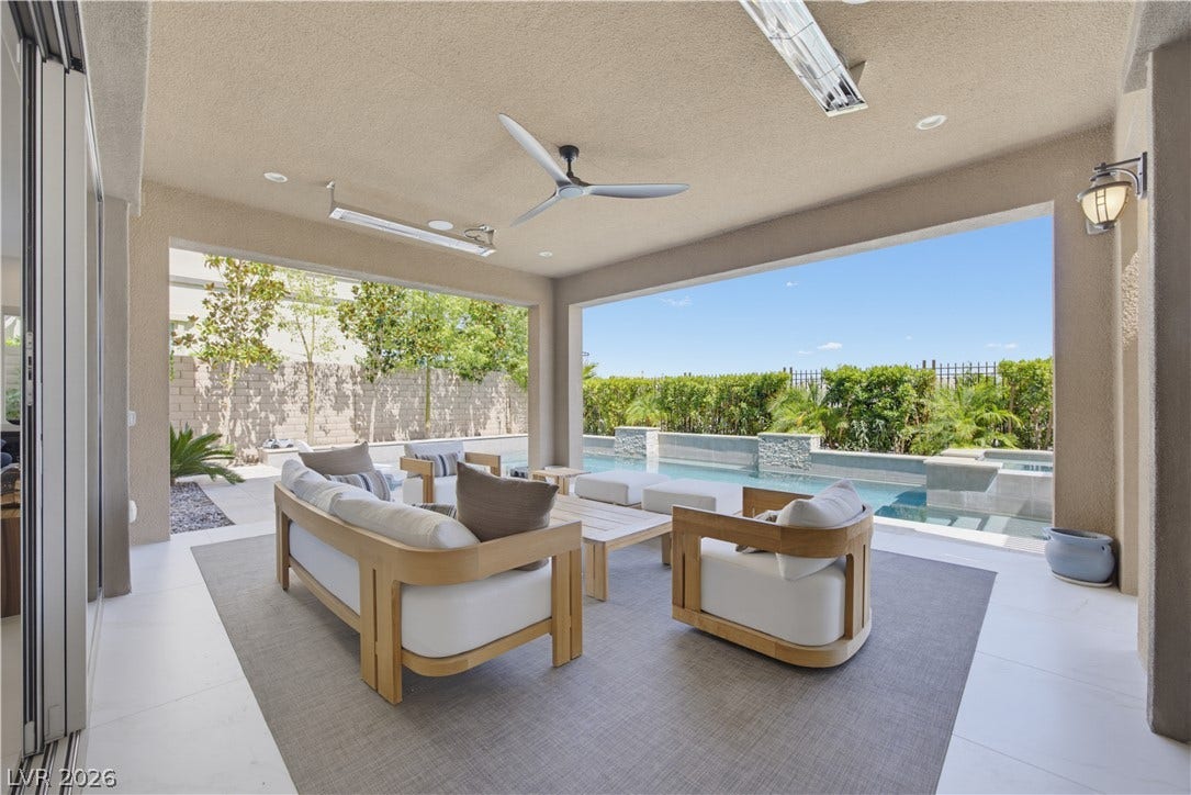 446 Bosco Di Fiore Street, Las Vegas, NV 89138 A covered patio overlooking a built-in swimming pool and private yard under clear blue skies.