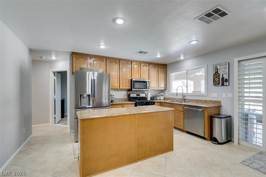 236 Fox Lake Avenue, Las Vegas, NV 89148 Granite countertops and a central island ground this spacious kitchen with tile flooring.
