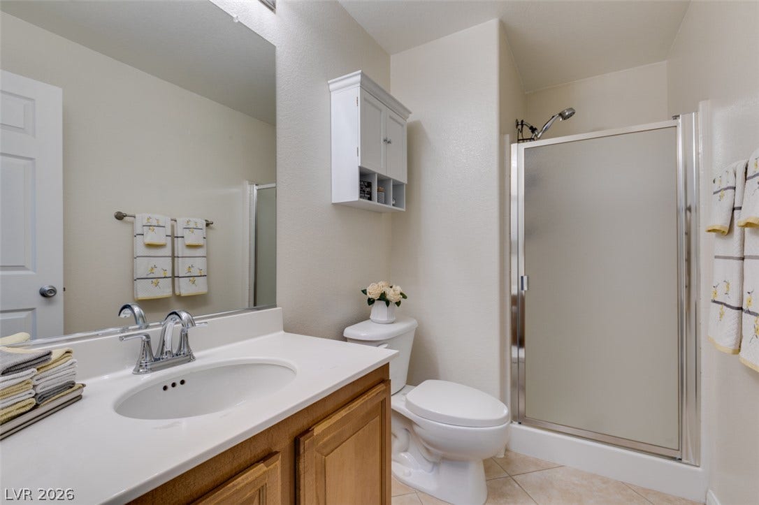 236 Fox Lake Avenue, Las Vegas, NV 89148 Functional vanity storage paired with a tiled walk-in shower defines this clean bathroom space.
