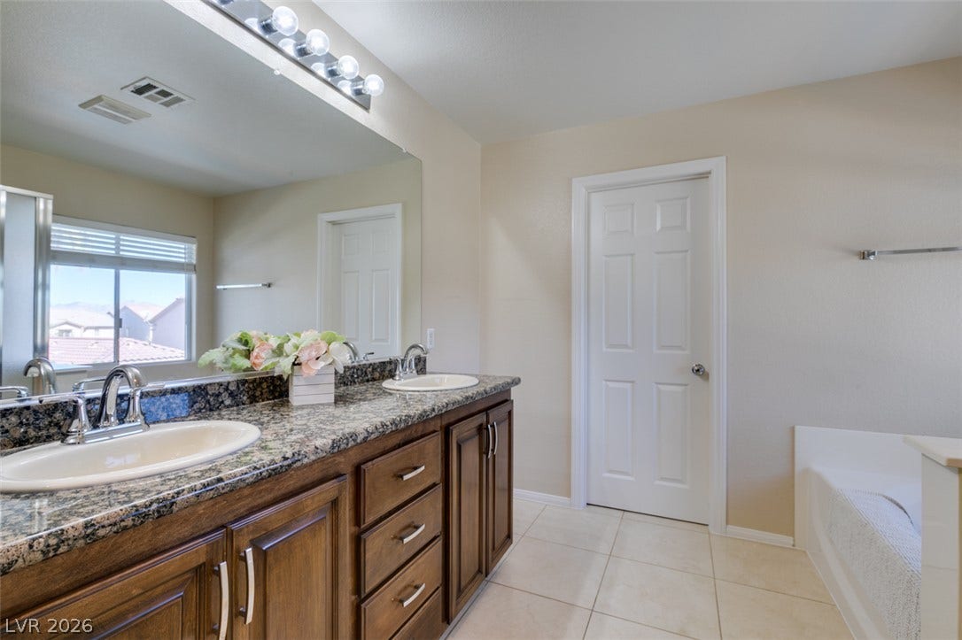 236 Fox Lake Avenue, Las Vegas, NV 89148 Granite counters and a spacious double vanity anchor this light-filled primary bath.