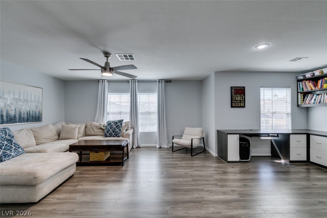 236 Fox Lake Avenue, Las Vegas, NV 89148 Gleaming wood-look floors anchor a versatile living space illuminated by recessed lighting.