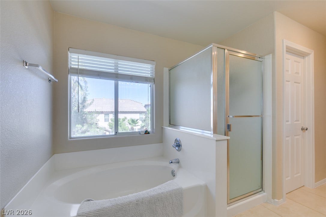 236 Fox Lake Avenue, Las Vegas, NV 89148 An inviting soaking tub pairs with a separate glass-enclosed shower in this bathroom.