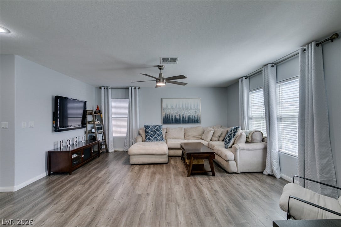 236 Fox Lake Avenue, Las Vegas, NV 89148 Gleaming wood-look floors anchor a spacious main living area illuminated by multiple windows.