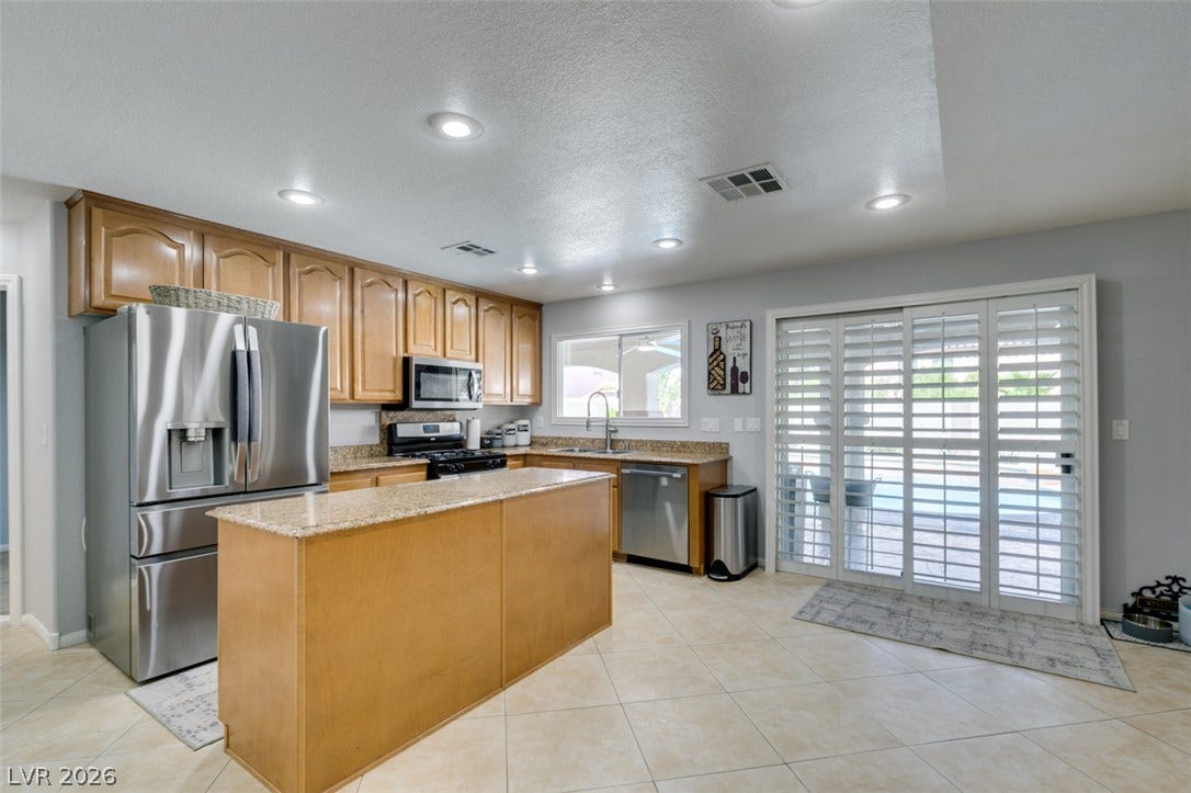 236 Fox Lake Avenue, Las Vegas, NV 89148 Gleaming tile floors and granite countertops define this classic kitchen layout.
