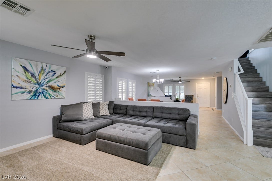 236 Fox Lake Avenue, Las Vegas, NV 89148 Tile and carpeted floors define this open living space adjacent to a prominent staircase.
