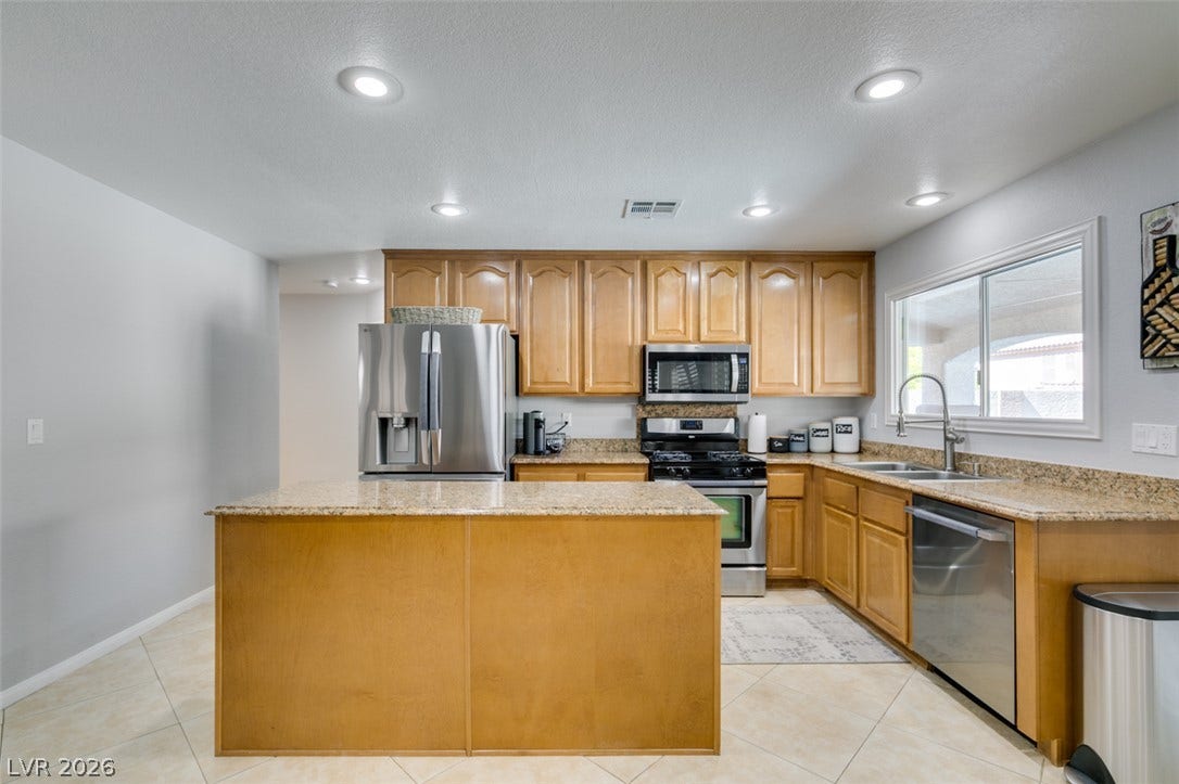 236 Fox Lake Avenue, Las Vegas, NV 89148 Granite countertops and wooden cabinetry anchor this culinary space featuring recessed lighting.