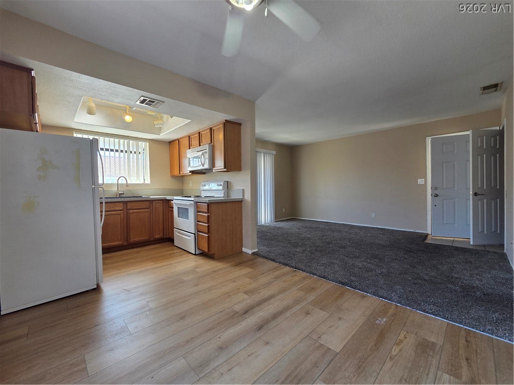 7300 Pirates Cove Road, #2060, Las Vegas, NV 89145 Plentiful cabinetry and neutral carpeting define this functional, open-concept living and dining area.