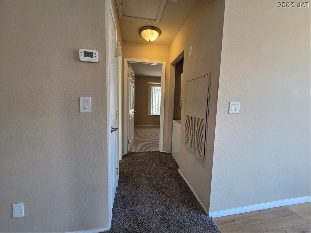 7300 Pirates Cove Road, #2060, Las Vegas, NV 89145 A hallway features plush carpeting and classic neutral walls leading to adjacent rooms.