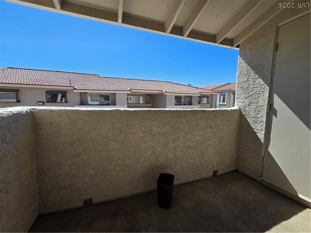 7300 Pirates Cove Road, #2060, Las Vegas, NV 89145 A private covered balcony overlooking the neighborhood features textured stucco walls.