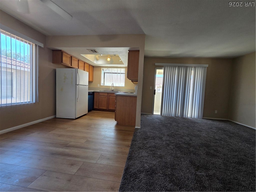 7300 Pirates Cove Road, #2060, Las Vegas, NV 89145 An open floorplan seamlessly connects the carpeted living area to the wood-floored kitchen.