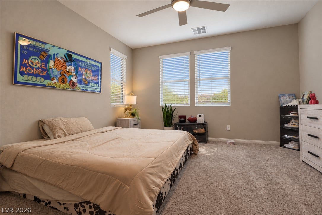 Wall-to-wall carpeting and multiple large windows define this comfortable secondary bedroom.