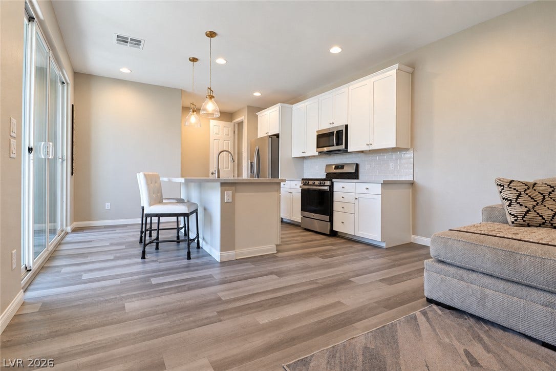 An open kitchen layout flows seamlessly into the living space under recessed lighting.