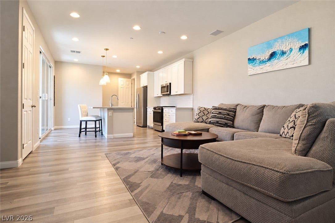 Recessed lighting and wood-look flooring flow throughout this bright open-concept living space.