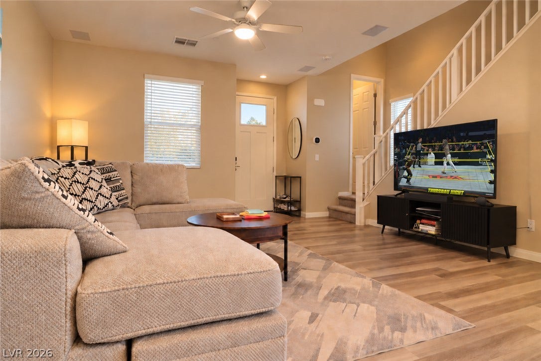 Warm wood-look flooring and soaring high ceilings define this inviting main-level living space.