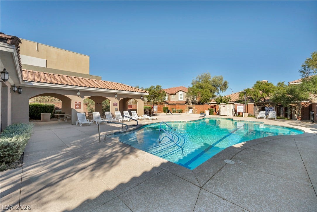 8577 Insignia Avenue, #101, Las Vegas, NV 89178 An inviting swimming pool is bordered by concrete decking and sheltered patio seating.