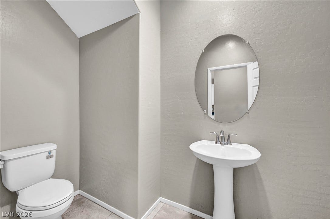 8577 Insignia Avenue, #101, Las Vegas, NV 89178 A classic pedestal sink paired with an oval mirror anchors this powder room.
