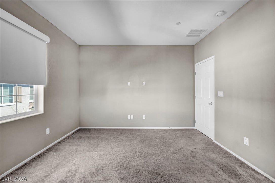 8577 Insignia Avenue, #101, Las Vegas, NV 89178 Plush carpeting and neutral-toned walls create a quiet, versatile space illuminated by natural light.
