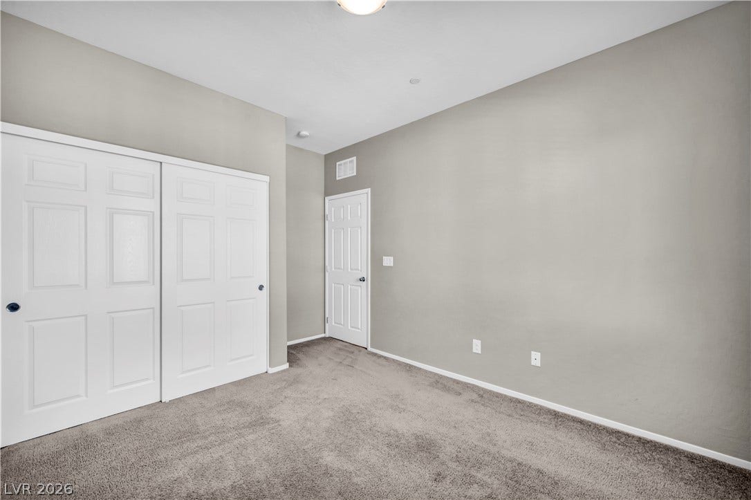8577 Insignia Avenue, #101, Las Vegas, NV 89178 Plush wall-to-wall carpeting and clean neutral walls anchor this serene secondary bedroom.