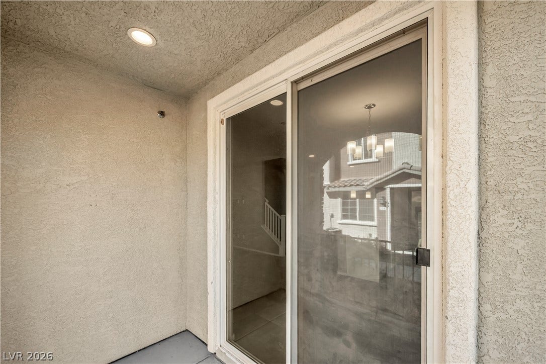 8577 Insignia Avenue, #101, Las Vegas, NV 89178 Sliding glass doors open onto a private stucco patio equipped with recessed lighting.