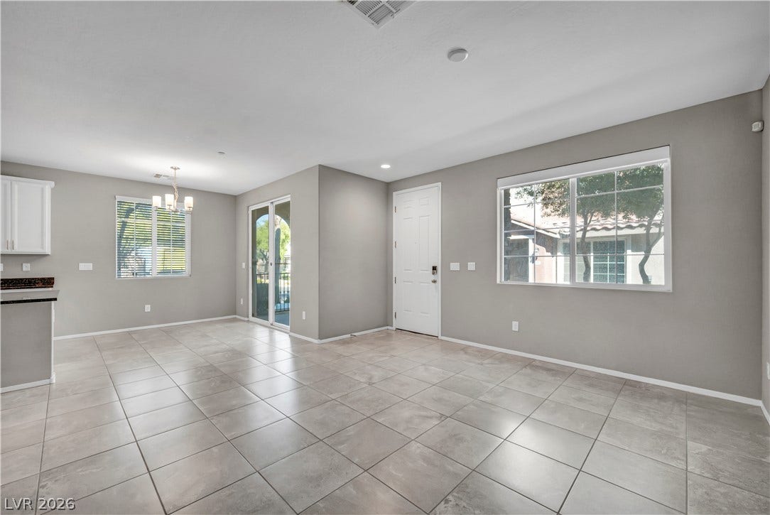 8577 Insignia Avenue, #101, Las Vegas, NV 89178 Gleaming tile floors and natural light from large windows define this versatile main living area.