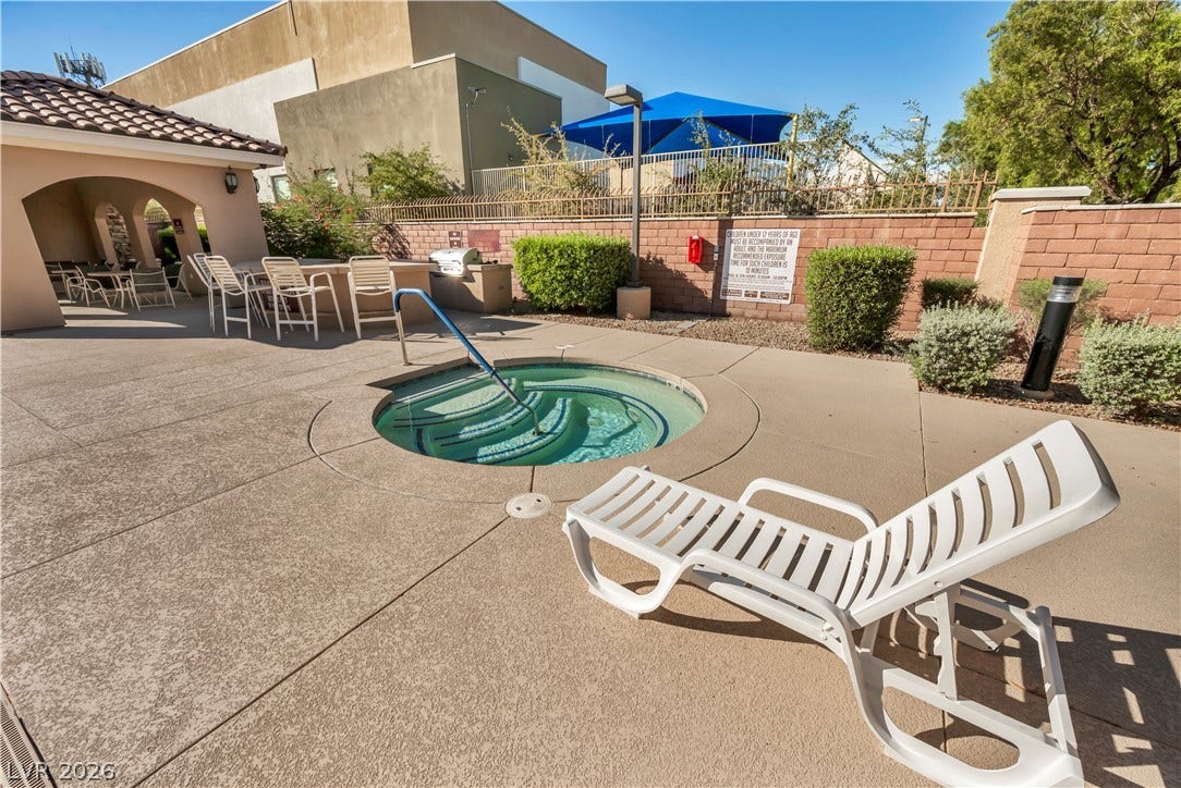 8577 Insignia Avenue, #101, Las Vegas, NV 89178 An inviting in-ground spa sits on a concrete deck surrounded by manicured landscaping.