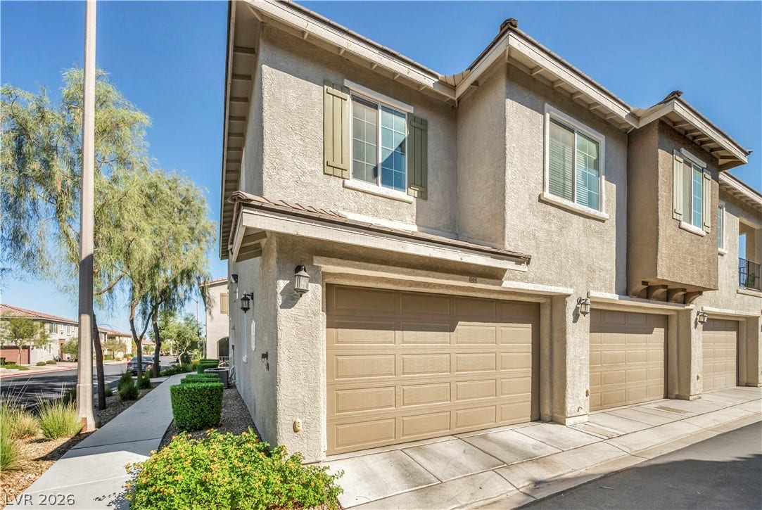 8577 Insignia Avenue, #101, Las Vegas, NV 89178 Stucco exterior and paneled garage doors define the architectural character of this multi-level townhome.
