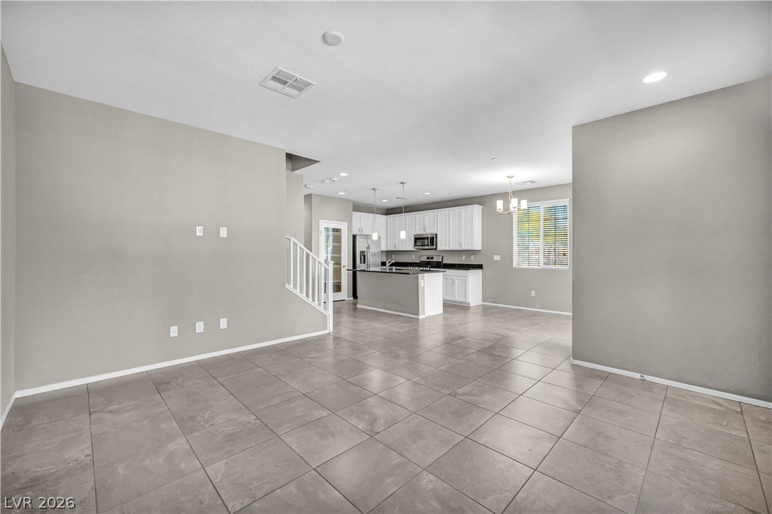 8577 Insignia Avenue, #101, Las Vegas, NV 89178 Gleaming tile floors guide the eye through an open layout connecting living and kitchen spaces.