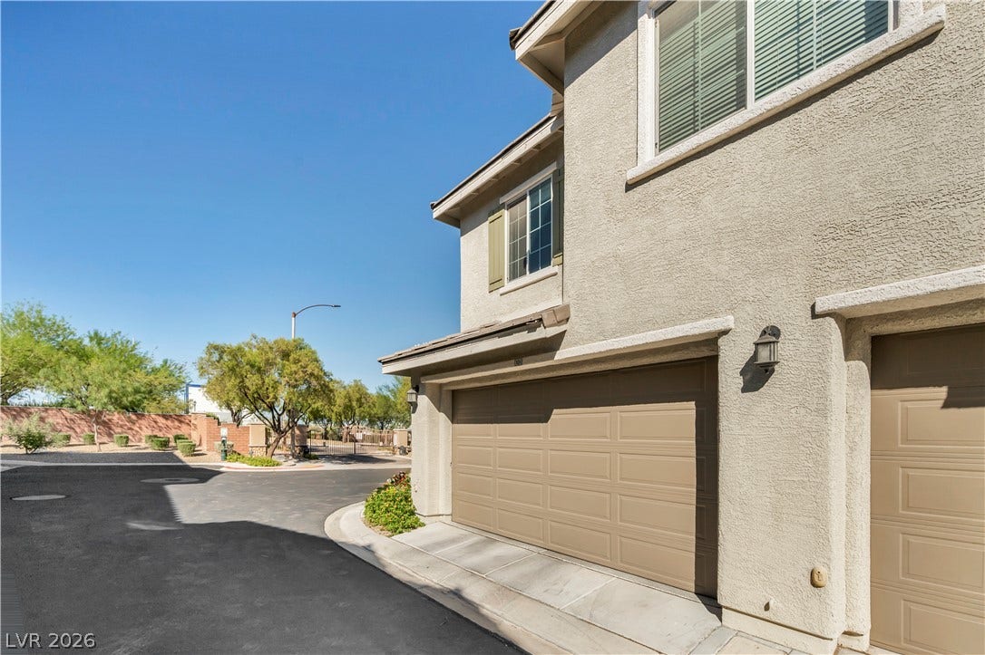 8577 Insignia Avenue, #101, Las Vegas, NV 89178 Multi-level stucco exterior showcases a multi-car garage on a paved cul-de-sac.