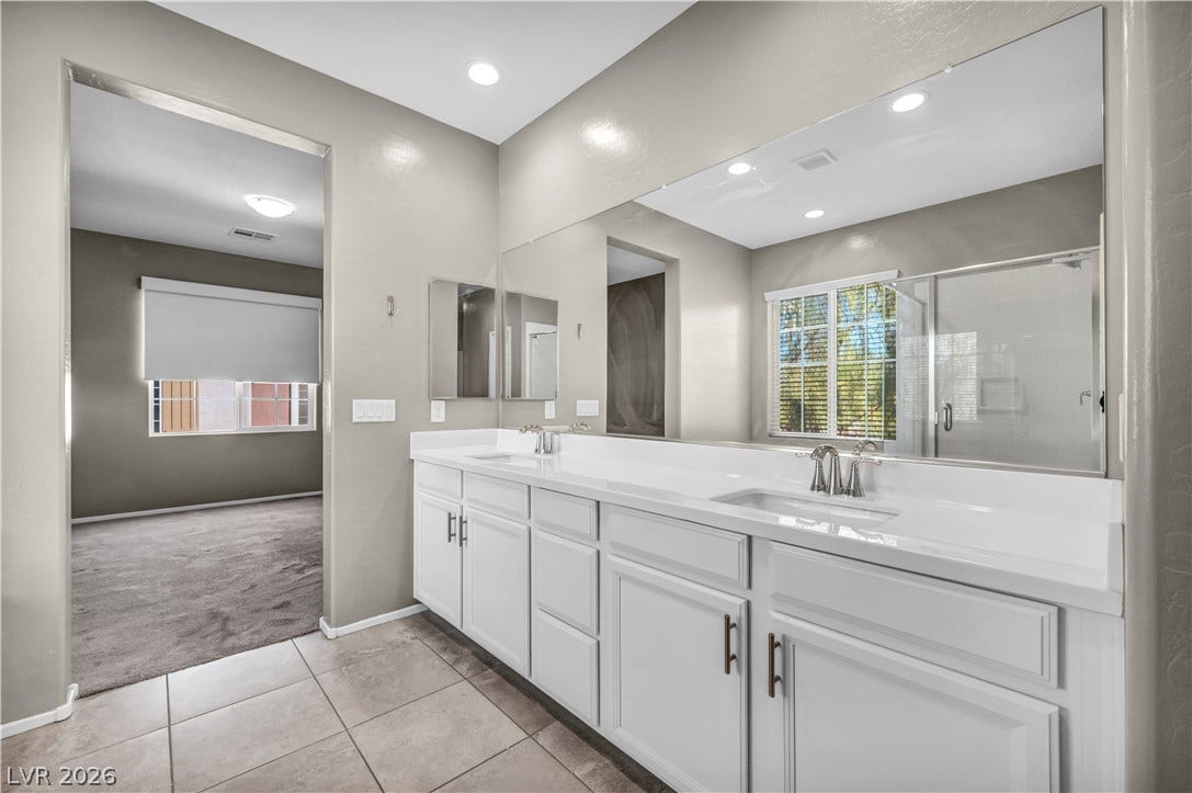 8577 Insignia Avenue, #101, Las Vegas, NV 89178 A spacious double vanity and tile flooring define this modern primary bath design.