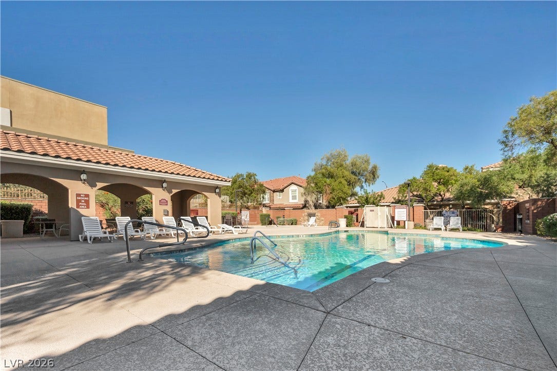 8577 Insignia Avenue, #101, Las Vegas, NV 89178 An inviting community swimming pool is surrounded by spacious concrete decking under a clear blue sky.