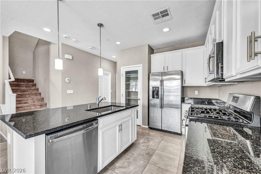8577 Insignia Avenue, #101, Las Vegas, NV 89178 Gleaming stone countertops and stainless steel appliances elevate this modern cooking space.
