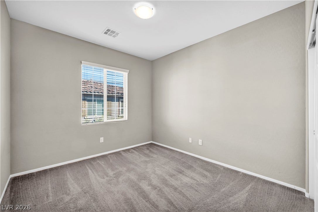 8577 Insignia Avenue, #101, Las Vegas, NV 89178 Plush carpeting and a wide window define this versatile bedroom space.