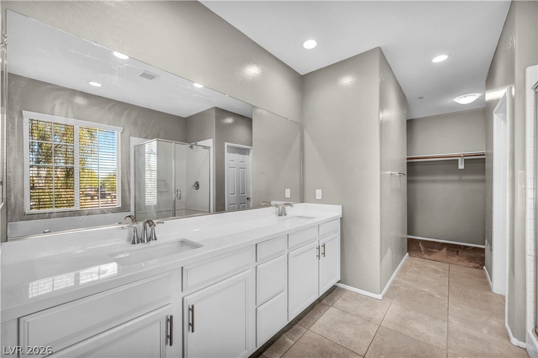 8577 Insignia Avenue, #101, Las Vegas, NV 89178 A spacious double vanity and tile flooring guide the way into the walk-in closet.