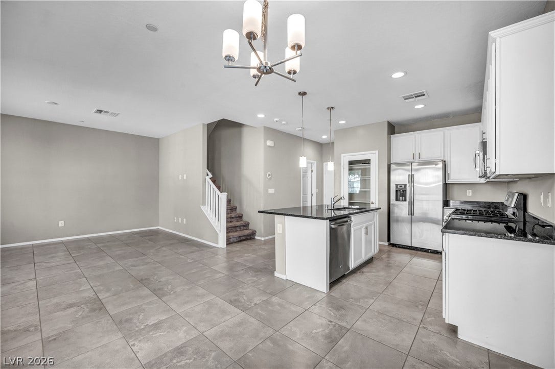 8577 Insignia Avenue, #101, Las Vegas, NV 89178 An open floorplan seamlessly connects the tiled kitchen and dining spaces near the staircase.