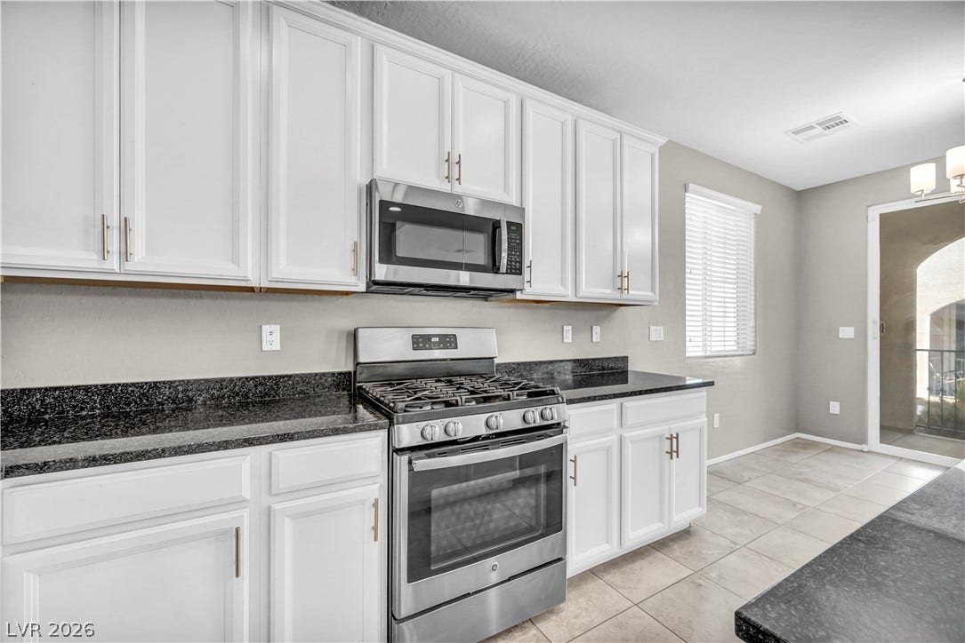 8577 Insignia Avenue, #101, Las Vegas, NV 89178 Gleaming stone countertops and classic cabinetry anchor this functional cooking space.