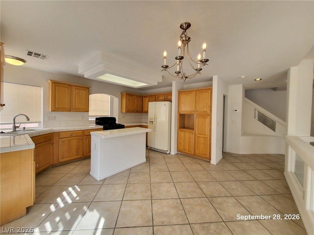 7619 Good Fortune Court, Las Vegas, NV 89139 Ample wooden cabinetry and durable tile flooring define this classic kitchen layout.