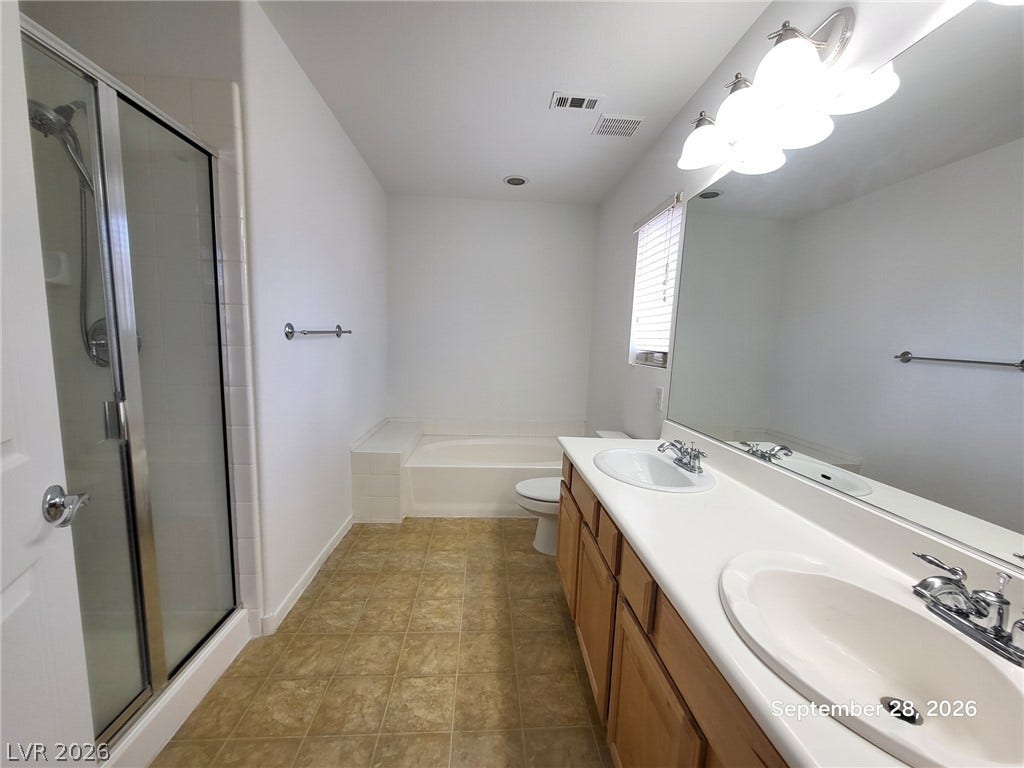 7619 Good Fortune Court, Las Vegas, NV 89139 A spacious bathroom layout features a double vanity and a separate soaking tub.