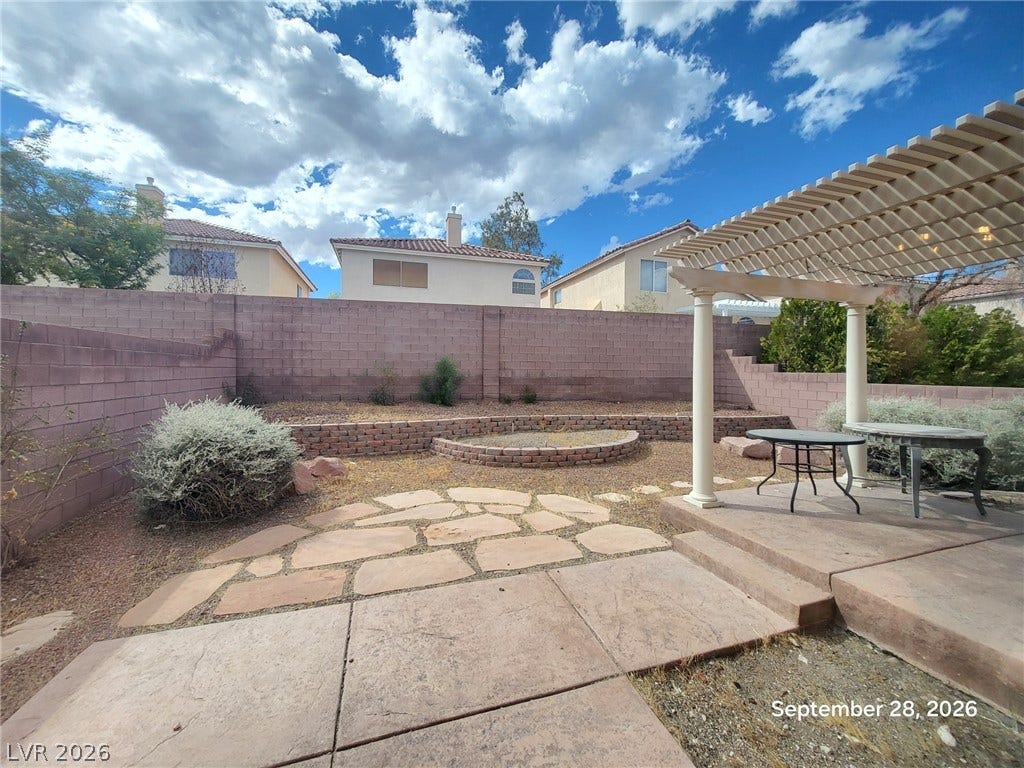 7619 Good Fortune Court, Las Vegas, NV 89139 A spacious concrete and stone patio is sheltered by an elegant backyard pergola structure.