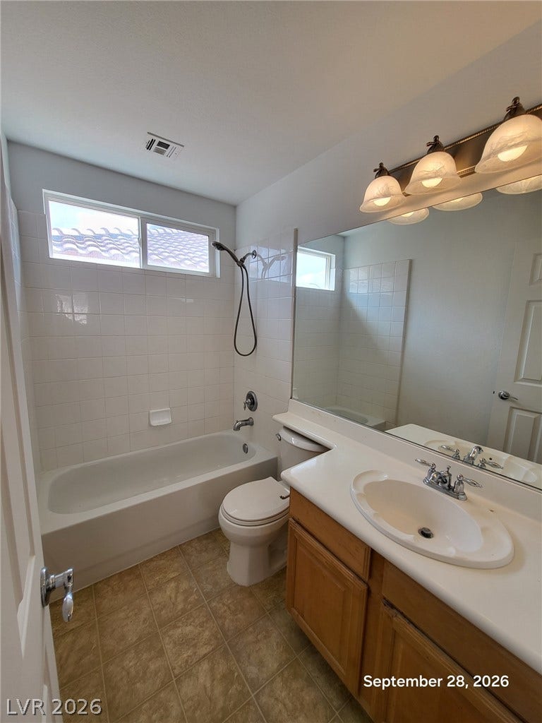 7619 Good Fortune Court, Las Vegas, NV 89139 Tiled tub surrounds and built-in vanity cabinetry anchor this functional bathroom layout.