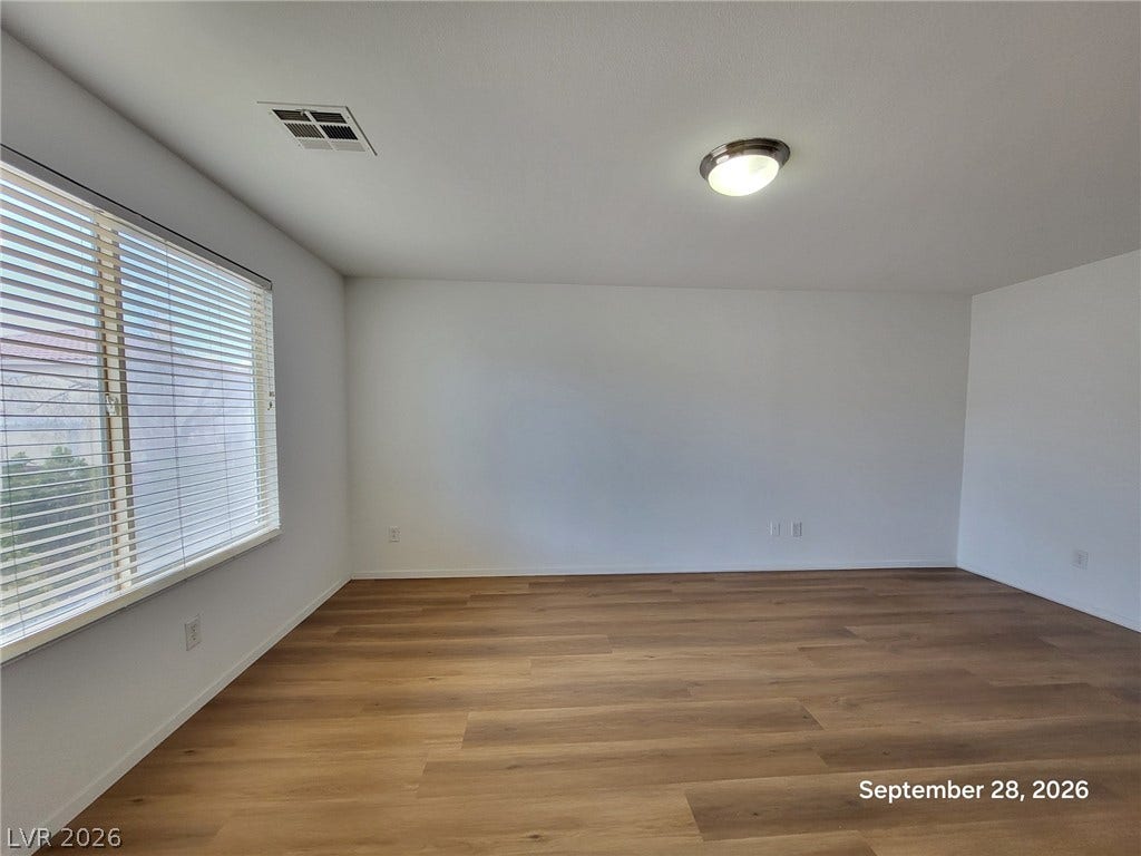 7619 Good Fortune Court, Las Vegas, NV 89139 Warm wood-style flooring complements the clean, neutral walls in this versatile living space.