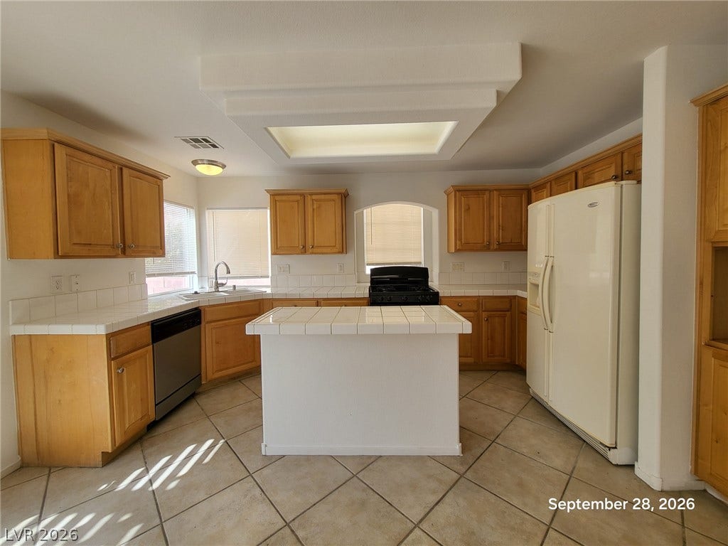 7619 Good Fortune Court, Las Vegas, NV 89139 Natural light pours through a central skylight onto classic wood cabinetry and tile floors.