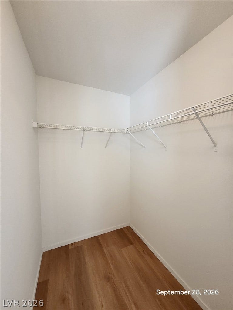 7619 Good Fortune Court, Las Vegas, NV 89139 Ample wire shelving lines this functional walk-in closet featuring warm wood-style flooring.