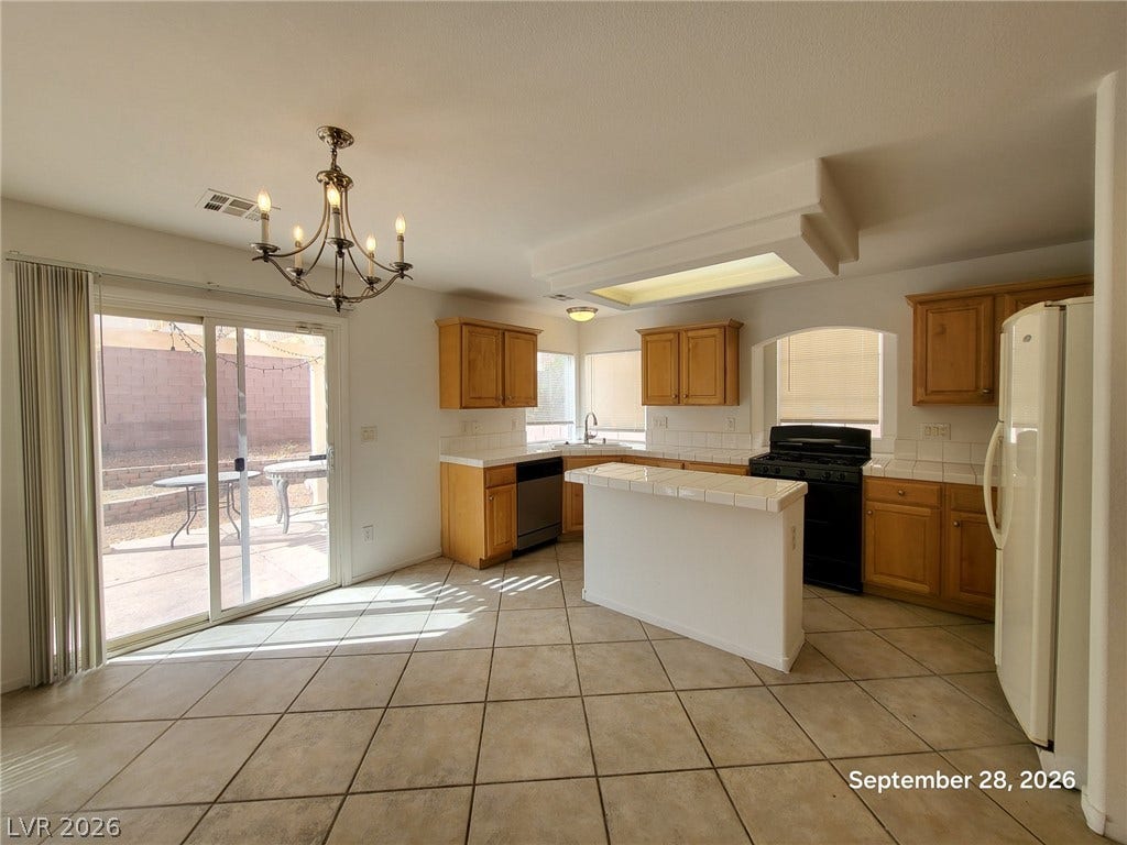 7619 Good Fortune Court, Las Vegas, NV 89139 Natural light pours across tile floors in this kitchen equipped with a central island.