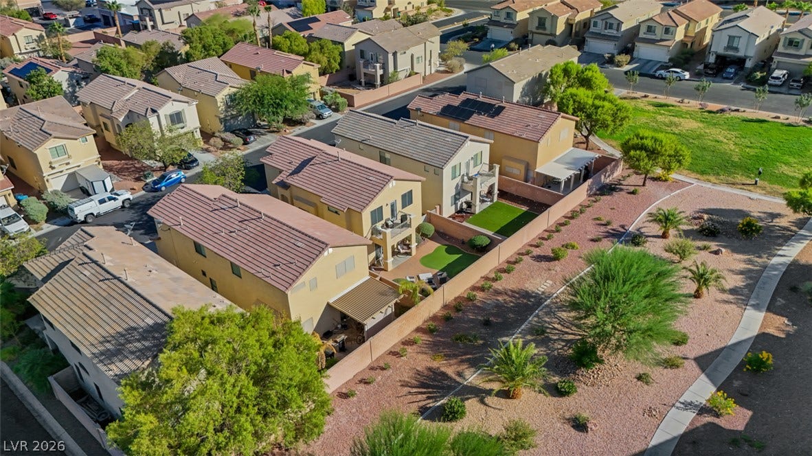 An aerial perspective showcases a neat residential neighborhood bordered by a landscaped green belt.