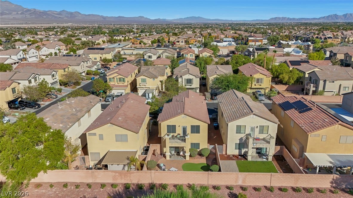 An aerial perspective showcases a neat residential neighborhood framed by majestic distant mountains.