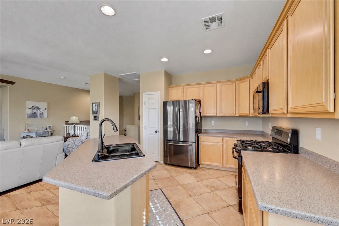 Gleaming tile floors and natural wood cabinetry anchor this open culinary space.
