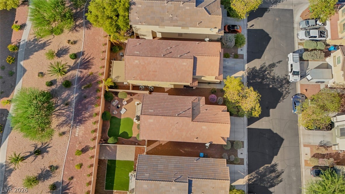 An aerial perspective captures the tiled roofs and landscaped yards of a quiet suburban neighborhood.