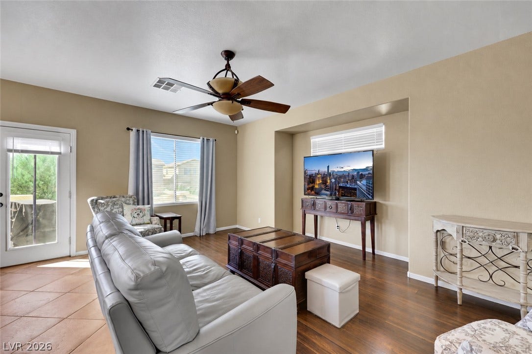 Rich floors and abundant natural light define this inviting gathering space. (AI used to remove contents of room).