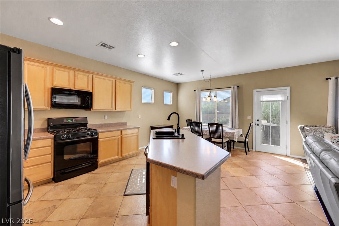 An open kitchen and dining layout is elevated by tiled flooring and recessed lighting.