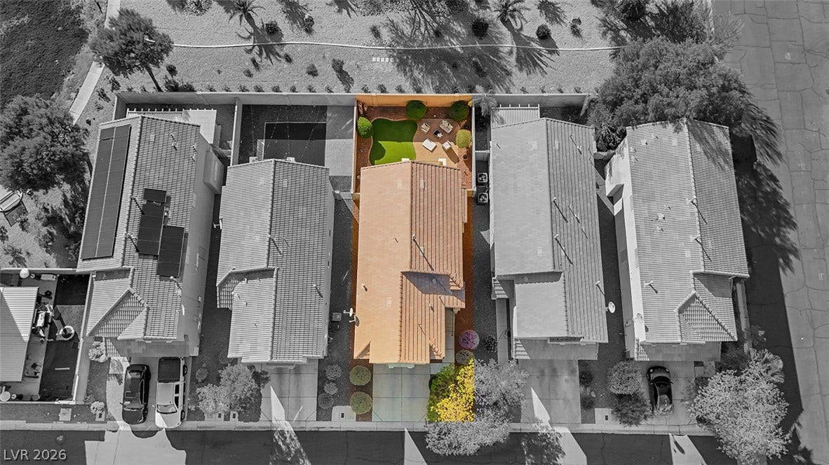 An aerial view highlights the neat tile roofline and private backyard of this suburban home.
